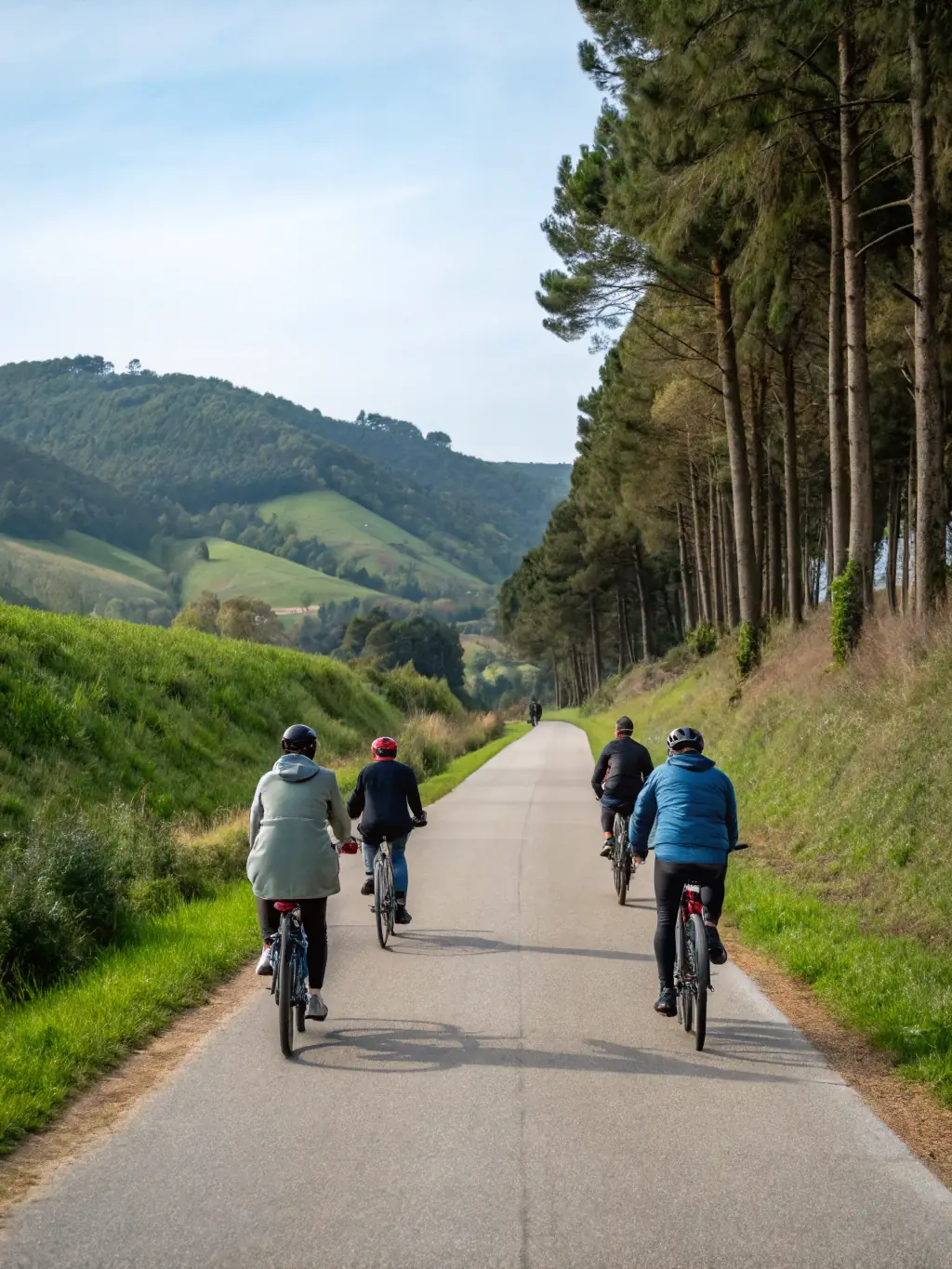 A group of cyclists riding along a coastal path in Pleubian, with the sea visible in the background, showcasing a scenic bicycle tour.
